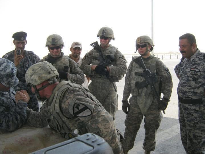 U.S. soldiers and Iraqi police talking together during a mission