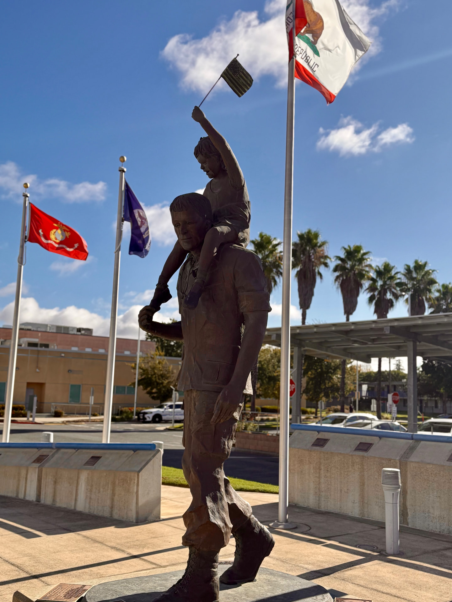 A California veterans memorial statue of a service member carrying a child waving an American flag